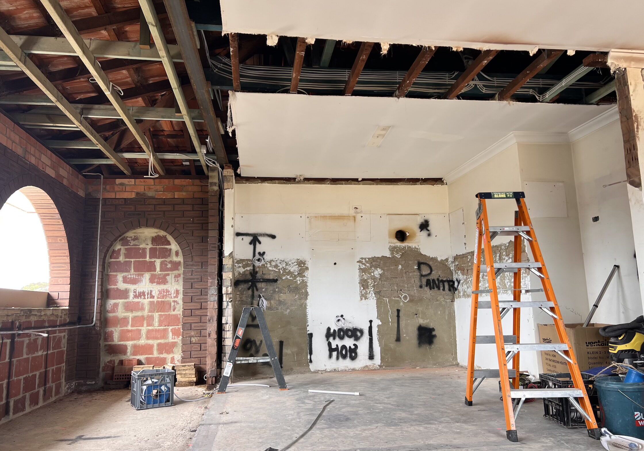Perth home mid renovation with the ceiling stripped back to the rafters and the new kitchen marked out on the walls